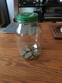 Photo of quart jar with a few bucks in it